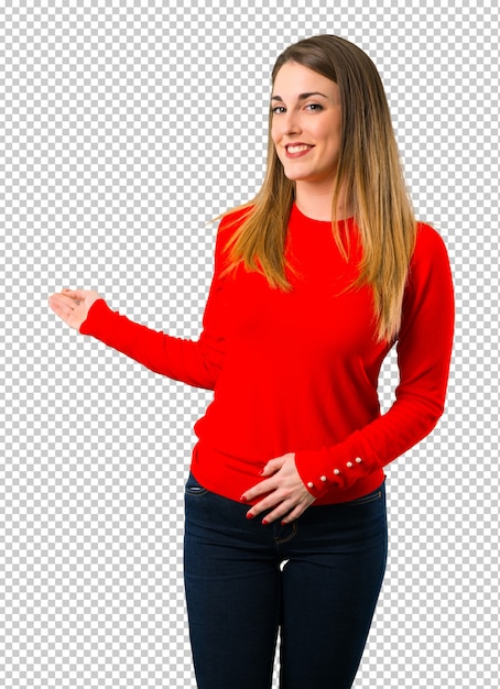 Mujer rubia joven que señala detrás con el dedo índice