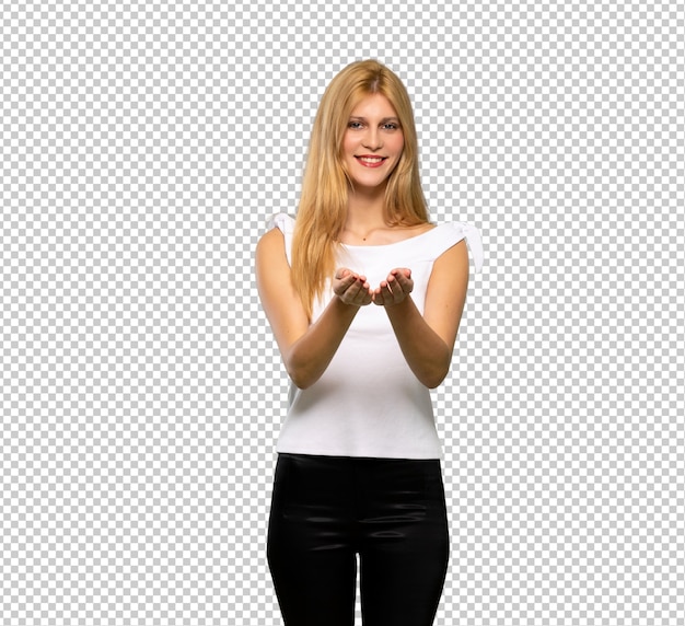 Mujer rubia joven que sostiene el copyspace imaginario en la palma para insertar un anuncio