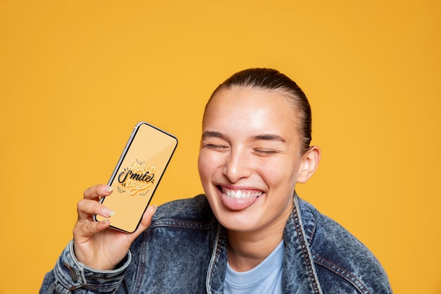 PSD mujer sonriendo y pasando un buen rato mientras sostiene la maqueta del teléfono