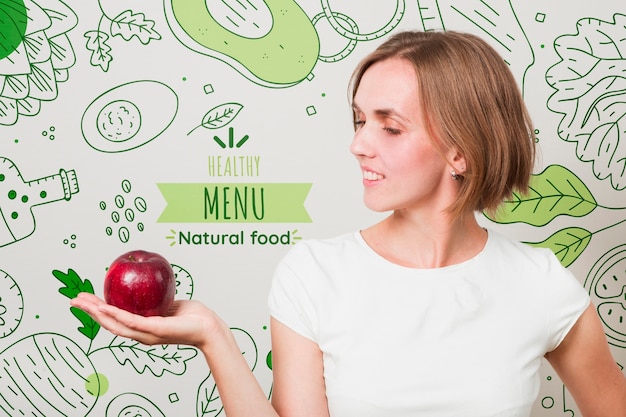 Mujer sonriente sujetando una manzana