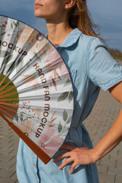 Mujer sosteniendo abanico con diseño de maqueta