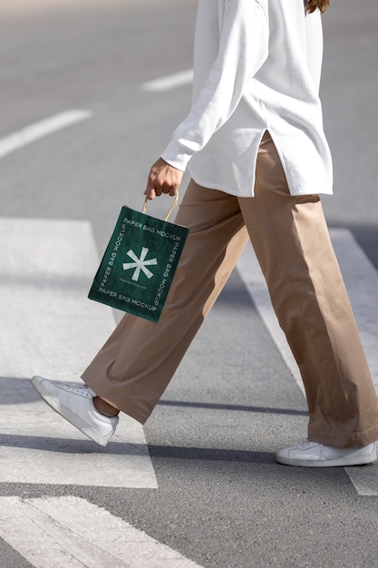 Mujer sosteniendo una bolsa de compras al aire libre en la calle