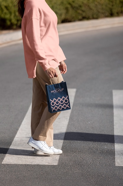 PSD mujer sosteniendo una bolsa de compras al aire libre en la calle