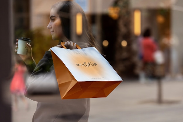 PSD mujer sosteniendo una bolsa de compras al aire libre en la calle