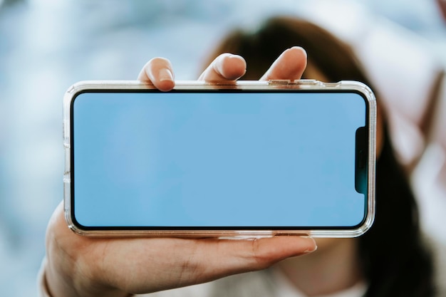 Mujer sosteniendo una maqueta de pantalla de teléfono móvil