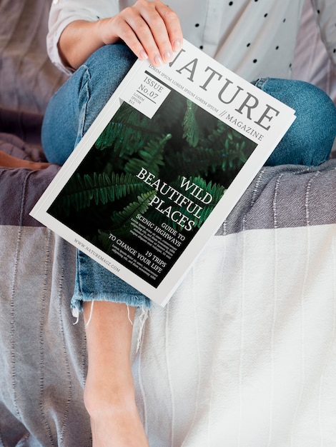 Mujer sosteniendo una revista de naturaleza junto a su pierna