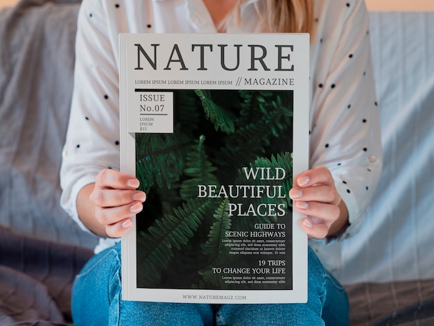 Mujer sosteniendo una revista sobre la naturaleza