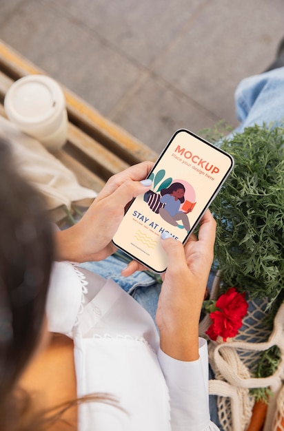 Mujer sosteniendo un smartphone de maqueta