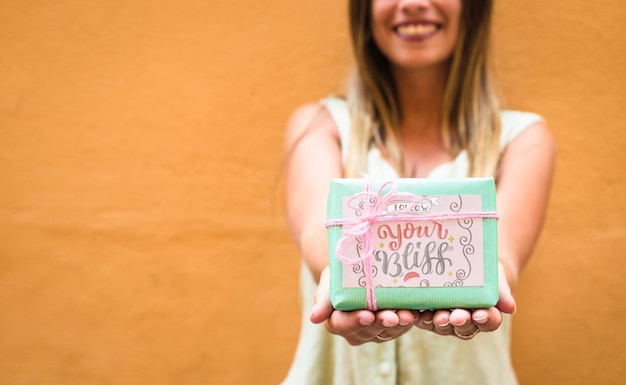 PSD mujer sujetando maqueta de caja de regalo