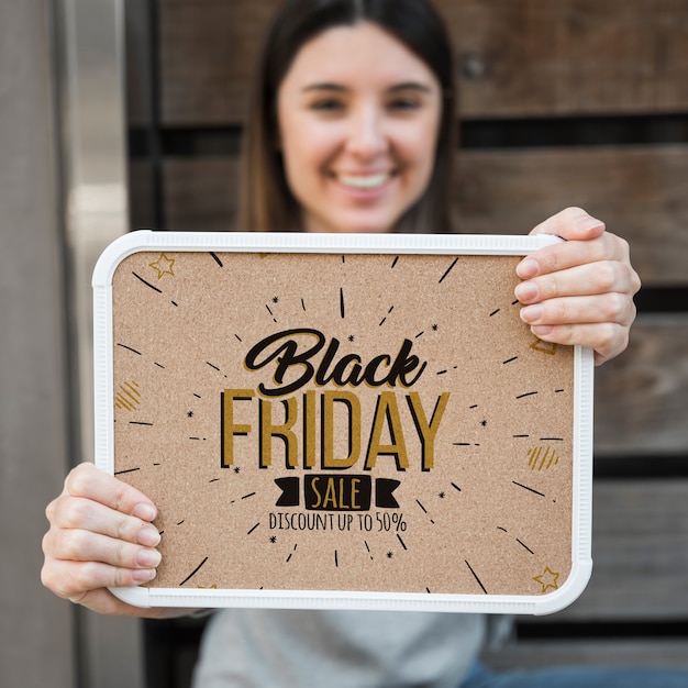 Mujer sujetando mockup de marco con concepto de black friday