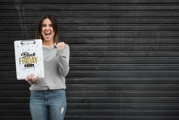 PSD mujer sujetando mockup de portapapeles con concepto de black friday