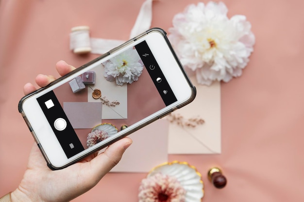 PSD mujer tomando una foto de un anillo de bodas y una invitación