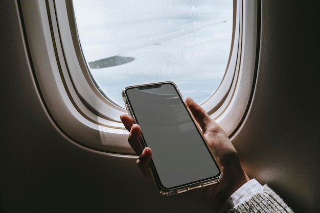 PSD mujer usando un teléfono inteligente en un avión