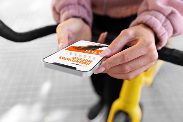 Mujer usando un teléfono inteligente simulado al aire libre mientras va en bicicleta