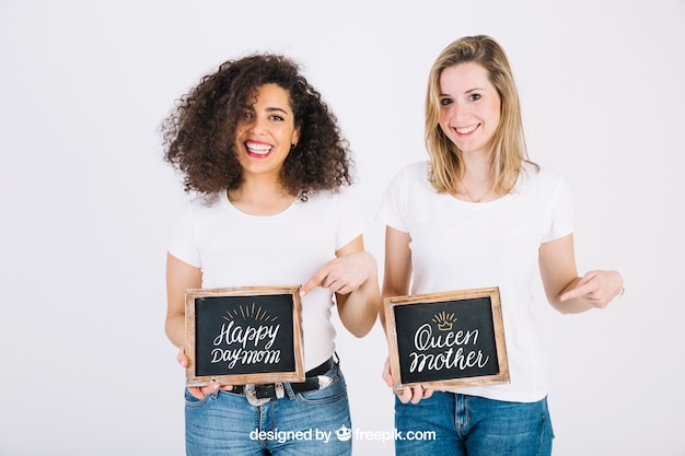 Mujeres felices enseñando pizarra