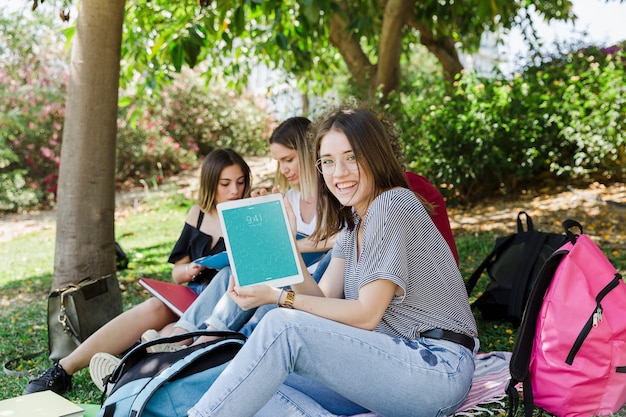 Mujeres mirando a mockup de tablet en parque