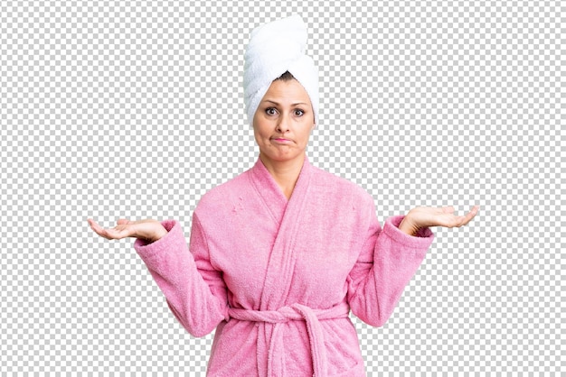 PSD mulher caucasiana de meia-idade em roupão de banho sobre fundo isolado tendo dúvidas enquanto levanta as mãos