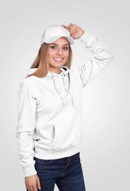 Mulher com capuz branco e boné a sorrir