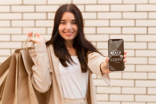 Mulher com maquete de smartphone preto sexta-feira