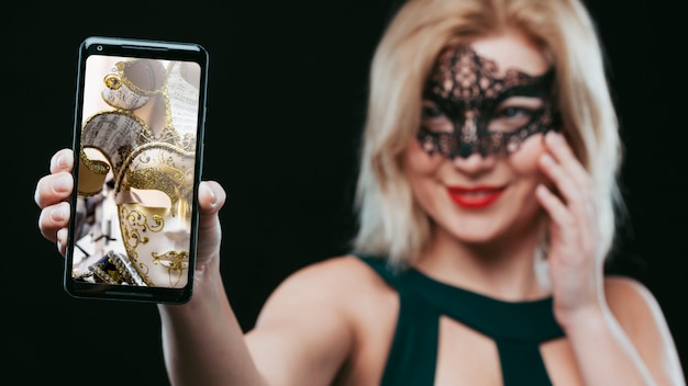 PSD mulher, com, máscara carnaval, mostrando, smartphone, mockup