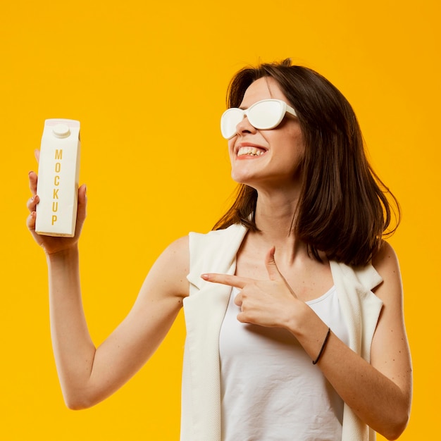 PSD mulher com óculos de sol, apontando para o leite