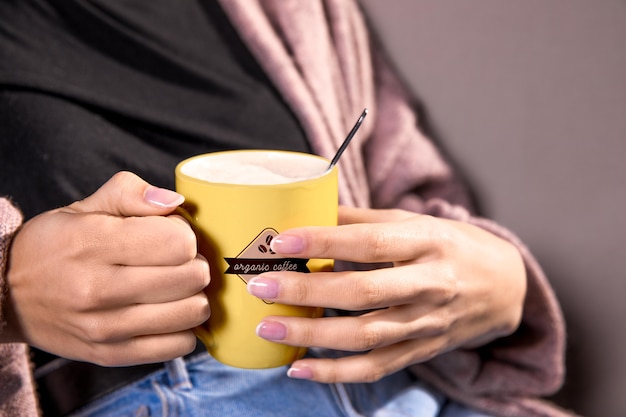 Mulher de close-up com caneca amarela