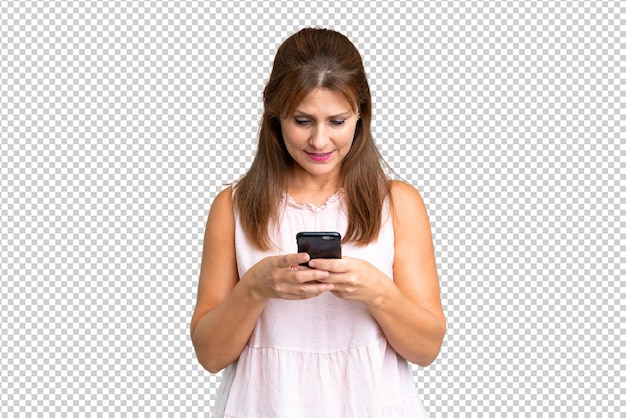 Mulher de meia-idade sobre um fundo isolado enviando uma mensagem com o celular
