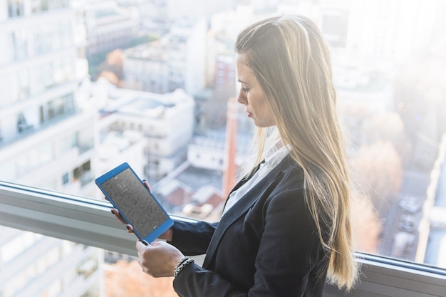 Mulher de negócios com tablet na frente do horizonte da cidade