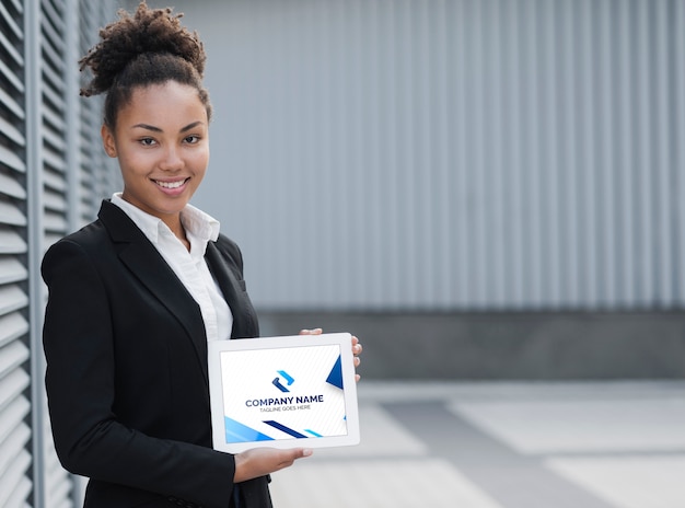 PSD mulher de negócios sorridente segurando mock-up tablet