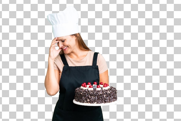 PSD mulher de pastry chef de meia-idade segurando um grande bolo sobre um fundo isolado rindo