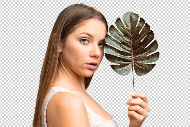 Mulher loira jovem sobre fundo de chave de croma isolado segurando uma folha de palmeira Retrato em close-up
