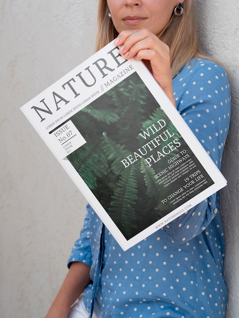 Mulher mostrando uma revista natureza mock up