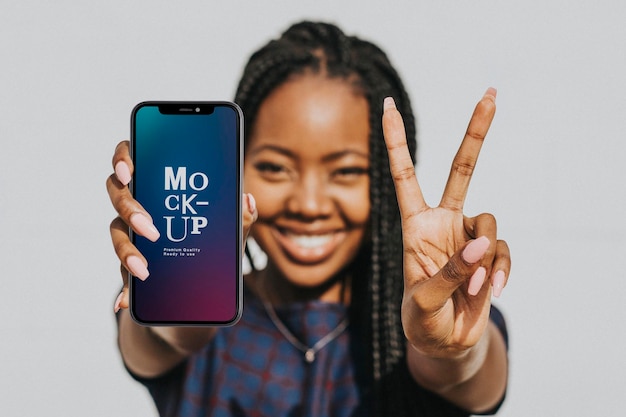 Mulher negra mostrando um sinal v com um modelo de telefone