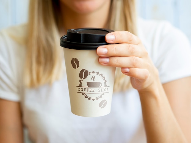 Mulher segurando um copo de papel de café