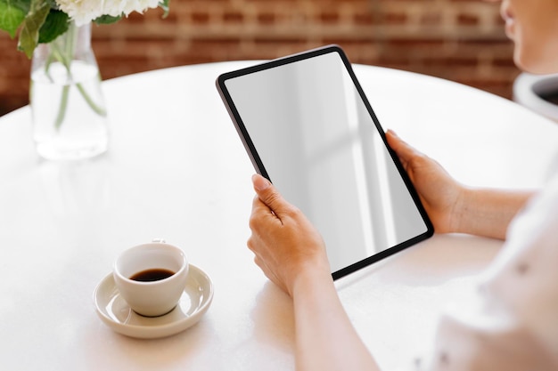 Mulher usando um tablet digital em uma maquete de café