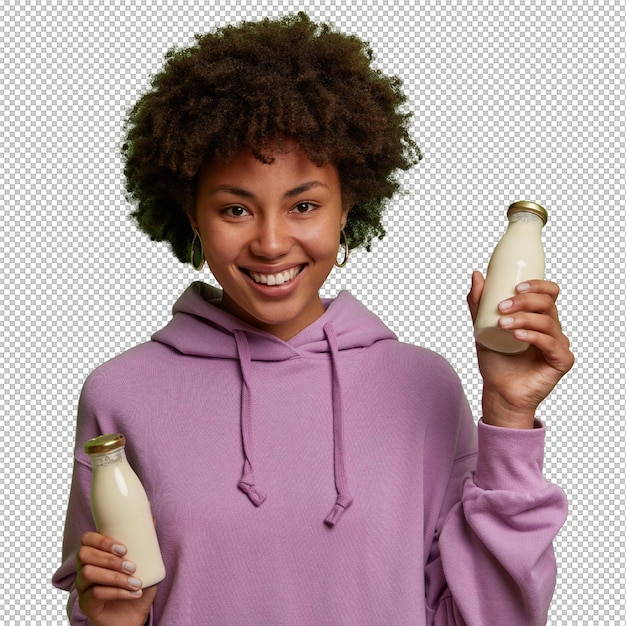 Mulher vegana feliz segura garrafas de vidro de leite sem lactose à base de plantas tem nutrição saudável usa capuz roxo sorri amplamente isolado sobre parede verde bebida alternativa não láctea