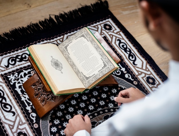 Muslimischer Mann, der den Koran studiert