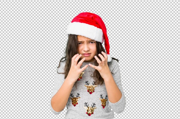 Niña celebrando el día de navidad molesto gritando con las manos tensas.