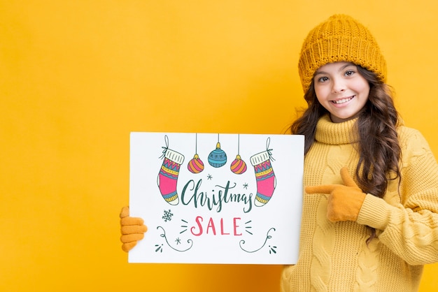 Niña con hoja de papel para ventas navideñas