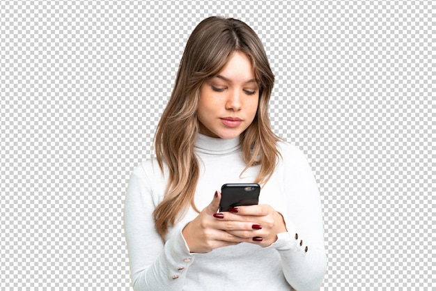 Niña joven sobre fondo de llave de croma aislado usando teléfono móvil
