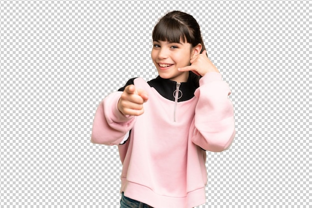 Niña pequeña sobre fondo de clave de croma verde aislado haciendo gesto de teléfono y apuntando hacia el frente