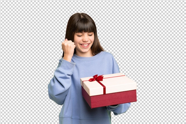 Niña sosteniendo un regalo sobre un fondo clave de croma aislado celebrando una victoria