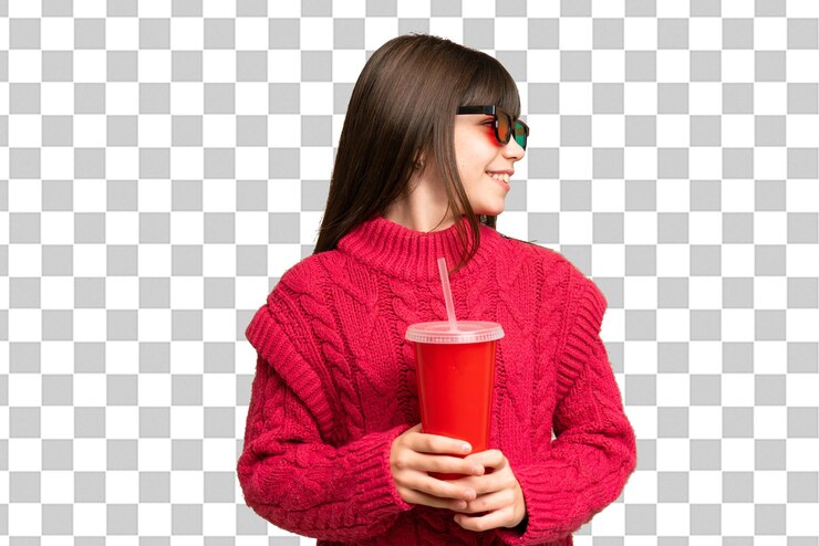 PSD niña sosteniendo soda sobre fondo de clave de croma aislado mirando hacia el lado