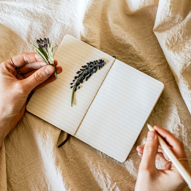Öffnetes Notebook-PSD-Mockup mit Blumen auf einer Leinendecke