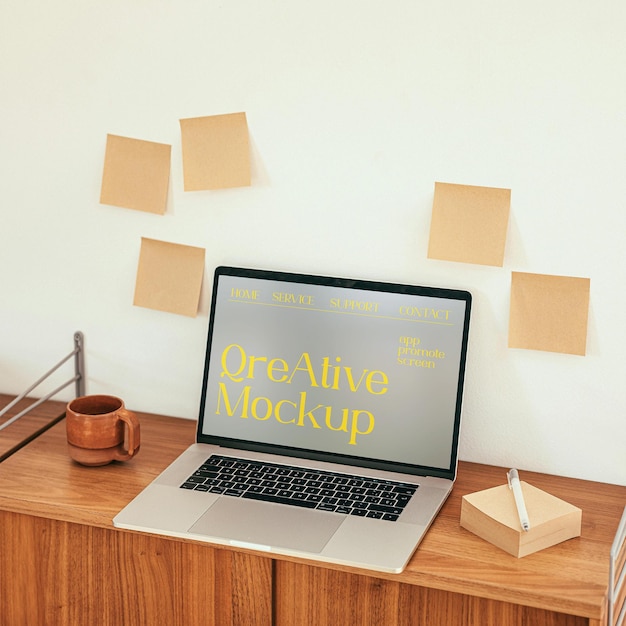 Un ordinateur portable sur la table et beaucoup d'autocollants sur le mur.