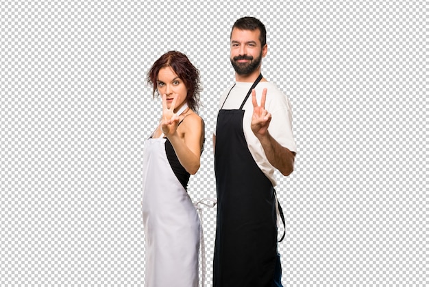Un par de cocineros felices y contando dos con los dedos