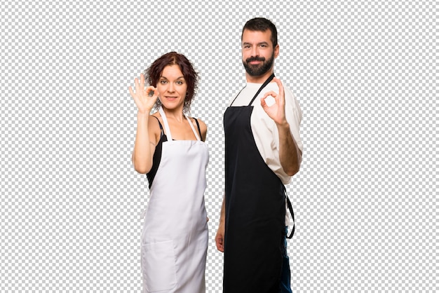 Par de cocineros mostrando un signo de ok con los dedos