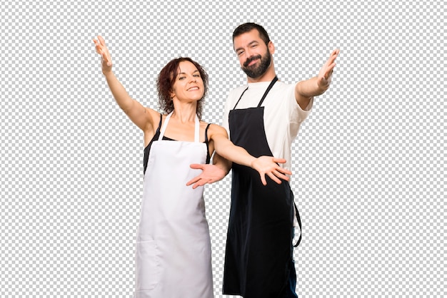 Un par de cocineros presentando e invitando a venir. Feliz de que hayas venido