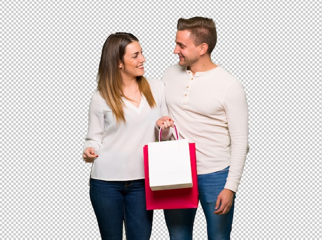 Pareja en el día de San Valentín con bolsas de compras en posición de victoria