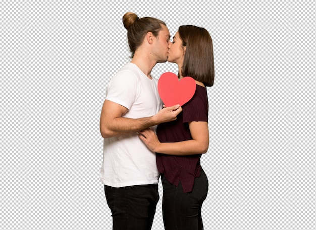Pareja en el día de San Valentín sosteniendo un símbolo de corazón y besándose
